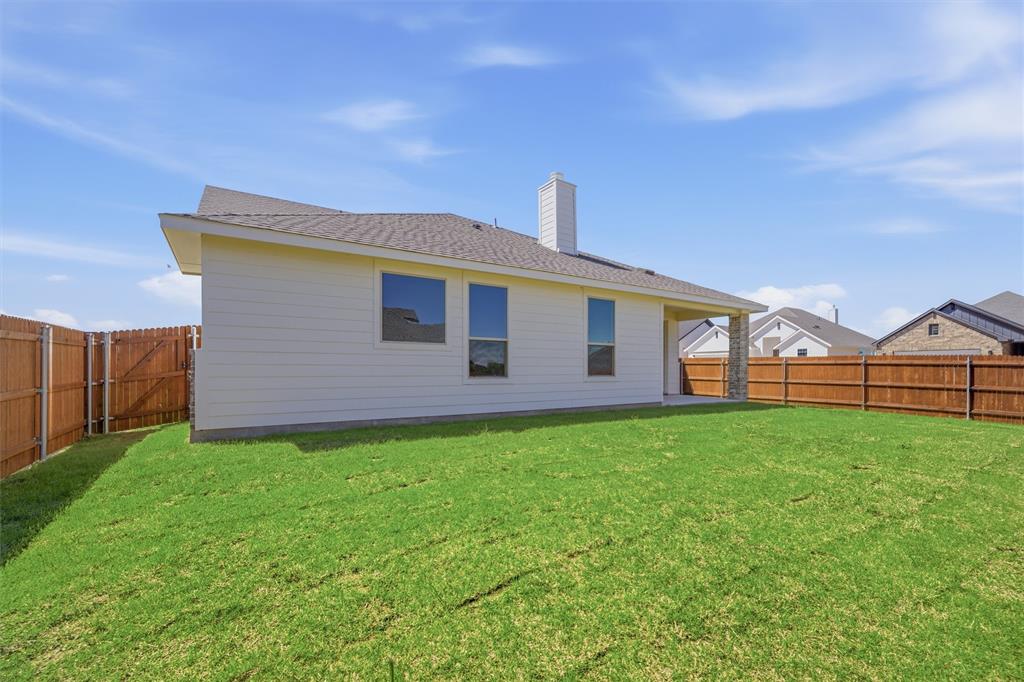 1221 Sabine River Lane Springtown, TX 76082 - Photo 24 of 25 Back of house featuring a chimney, a fenced backyard, a shingled roof, and a patio