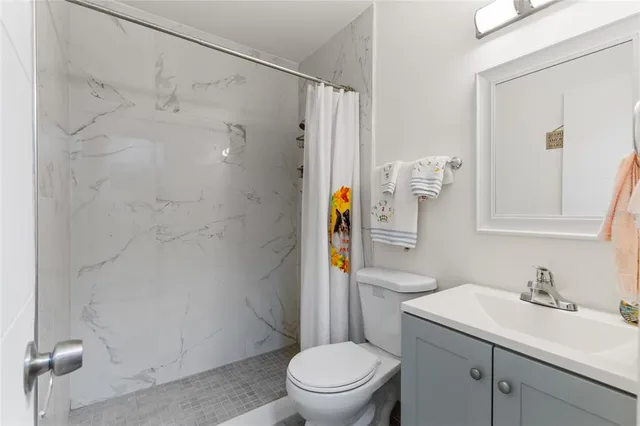 a bathroom with a sink toilet vanity and shower