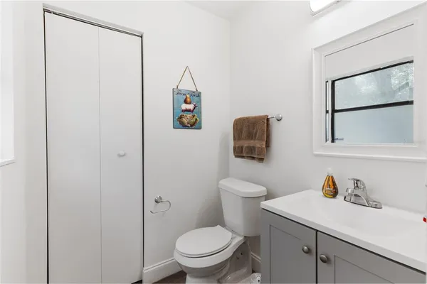 a bathroom with a toilet sink vanity and mirror