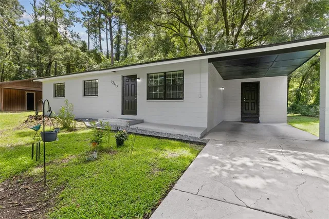 a view of a house with backyard and sitting area