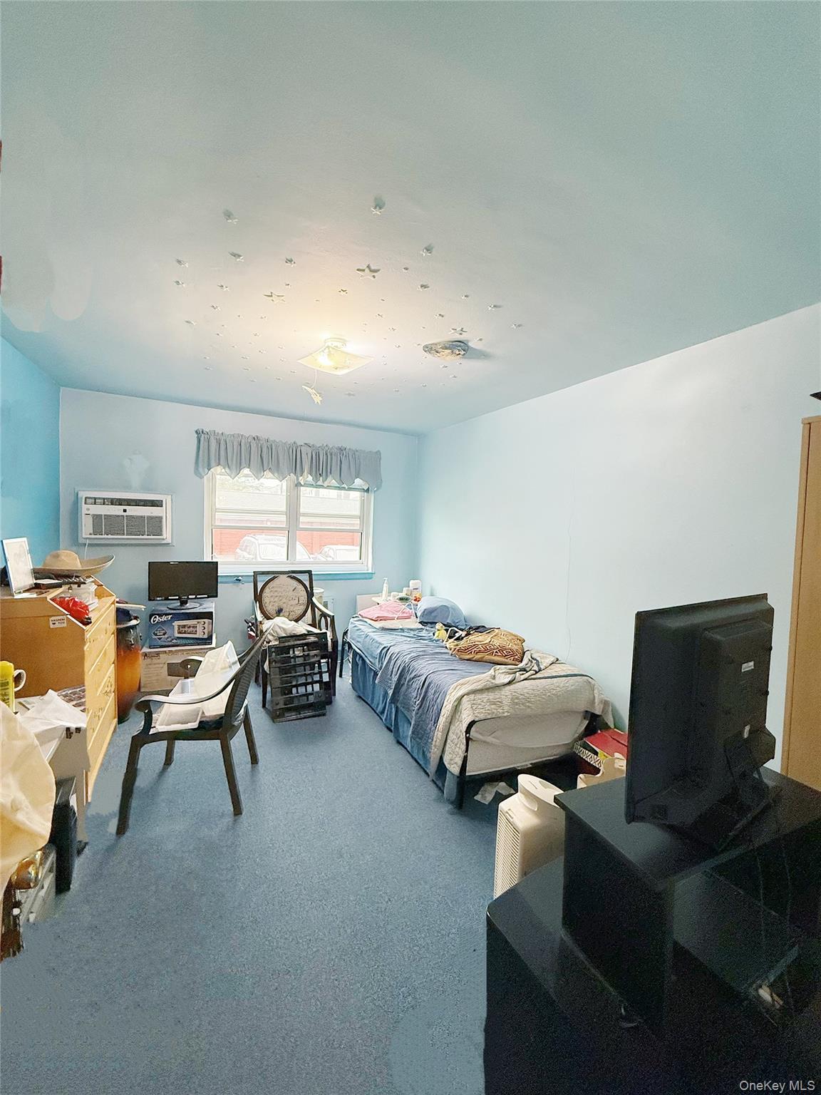 14930 Melbourne Avenue, Unit 395A Queens, NY 11367 - Photo 7 of 8 a living room with furniture and a flat screen tv