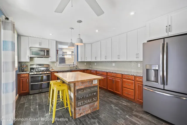 a kitchen with stainless steel appliances granite countertop a refrigerator a stove top oven a sink and dishwasher