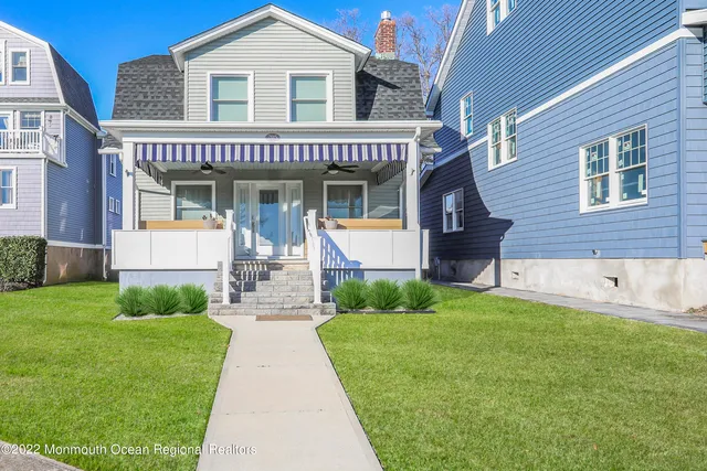 a front view of a house with a yard and potted plants