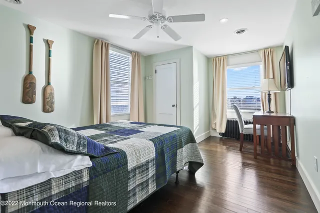 a bedroom with a bed a chandelier and a large window