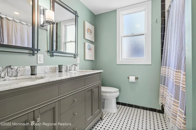 a bathroom with a granite countertop sink toilet a mirror and a shower