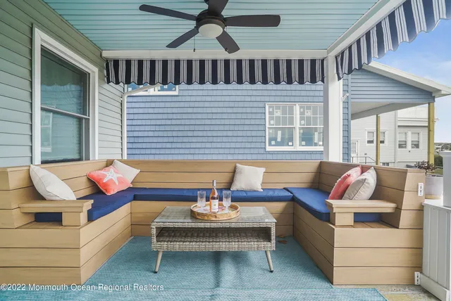 a outdoor space with patio couches a fireplace and a chandelier