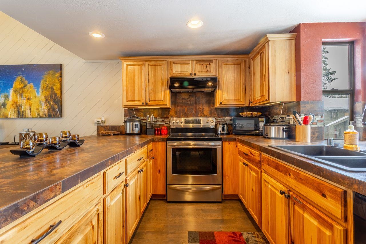 384 Joaquin Road, Unit 38 Mammoth Lakes, CA 93546 - Photo 11 of 30 a kitchen with stainless steel appliances a stove sink and cabinets