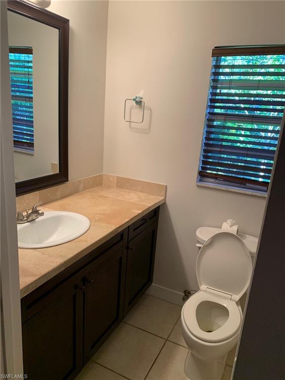 2075 17th Street Southwest Naples, FL 34117 - Photo 11 of 13 a bathroom with a sink a toilet and a mirror