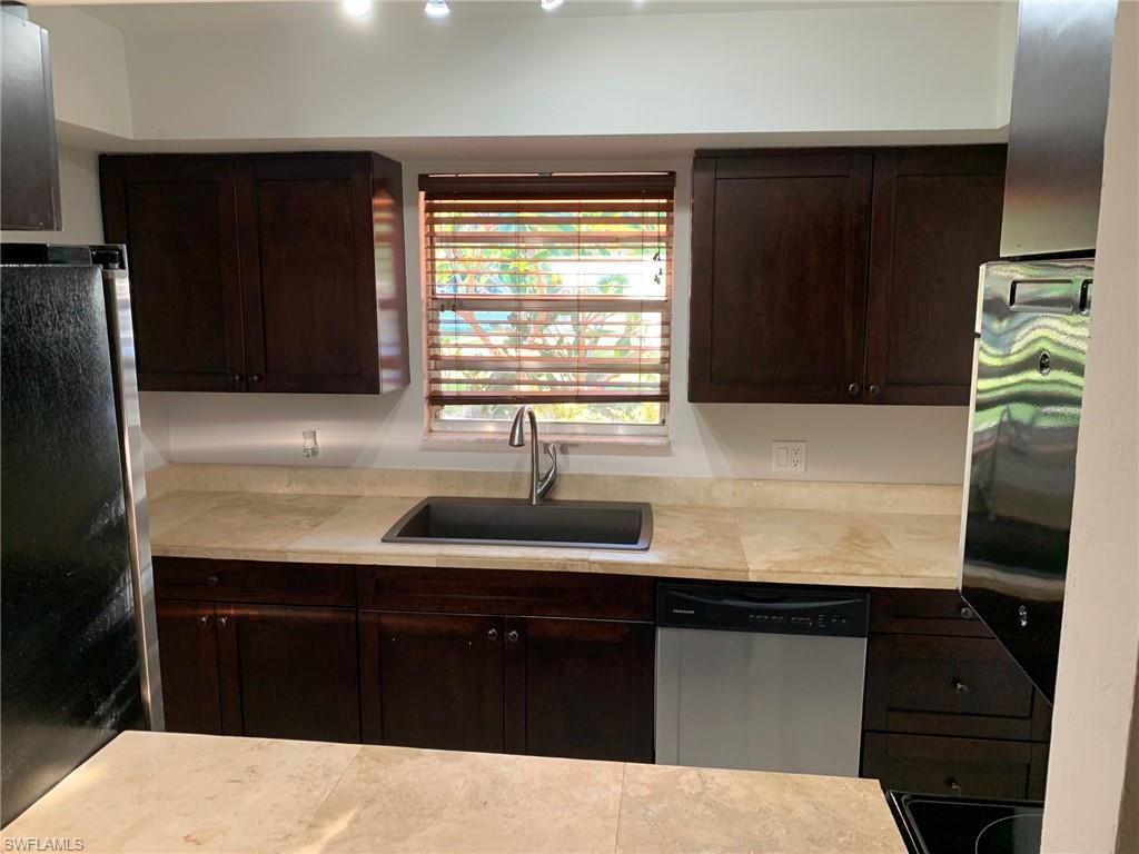 2075 17th Street Southwest Naples, FL 34117 - Photo 8 of 13 a kitchen with a sink a refrigerator and window