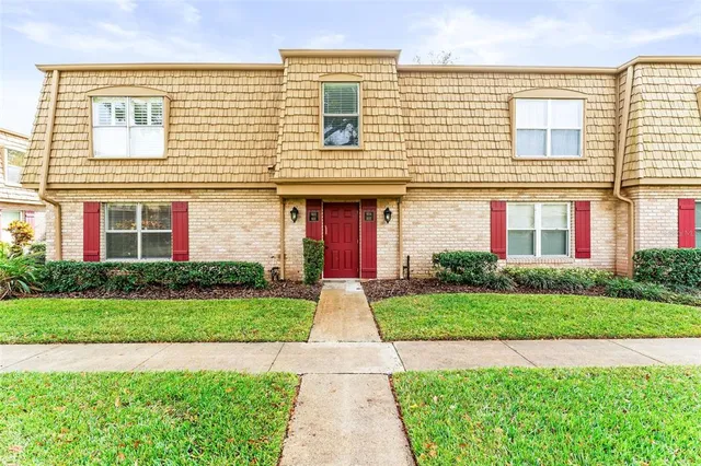 front view of a brick house with a yard