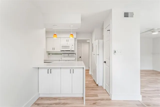 a view of kitchen with stainless steel appliances cabinets and wooden floor