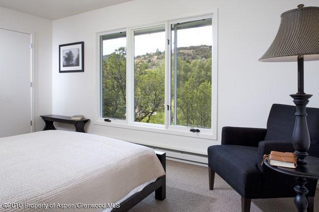 230 Riverside Drive Basalt, CO 81621 - Photo 7 of 12 a bedroom with a bed and a couch next to a window