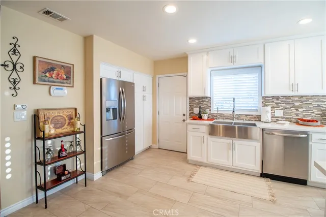 a kitchen with stainless steel appliances a refrigerator and a stove top oven