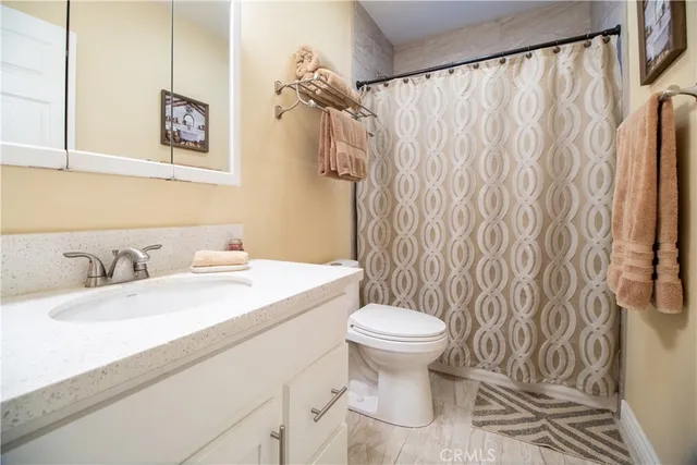 a bathroom with a sink a toilet and a mirror