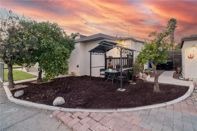 a view of a house with backyard and sitting area