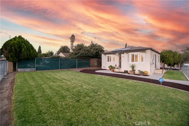 a view of a house with backyard and sitting area