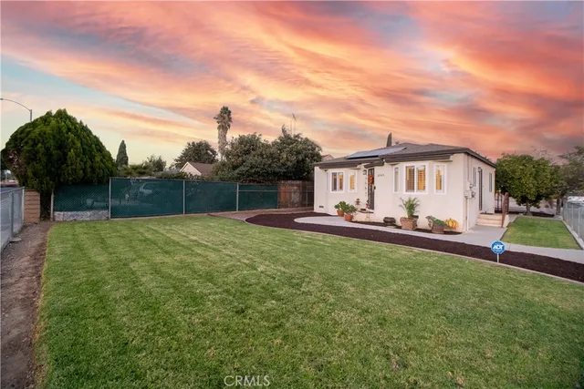 a view of a house with backyard and sitting area