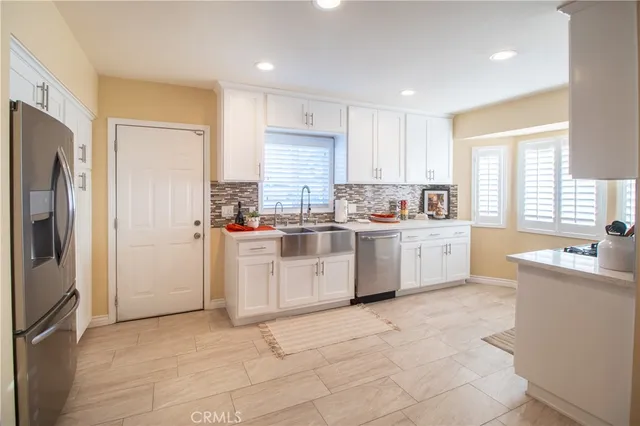 a kitchen with a sink a refrigerator and cabinets