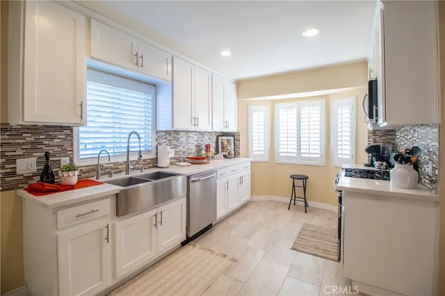 a kitchen with a sink stove cabinets and wooden floor