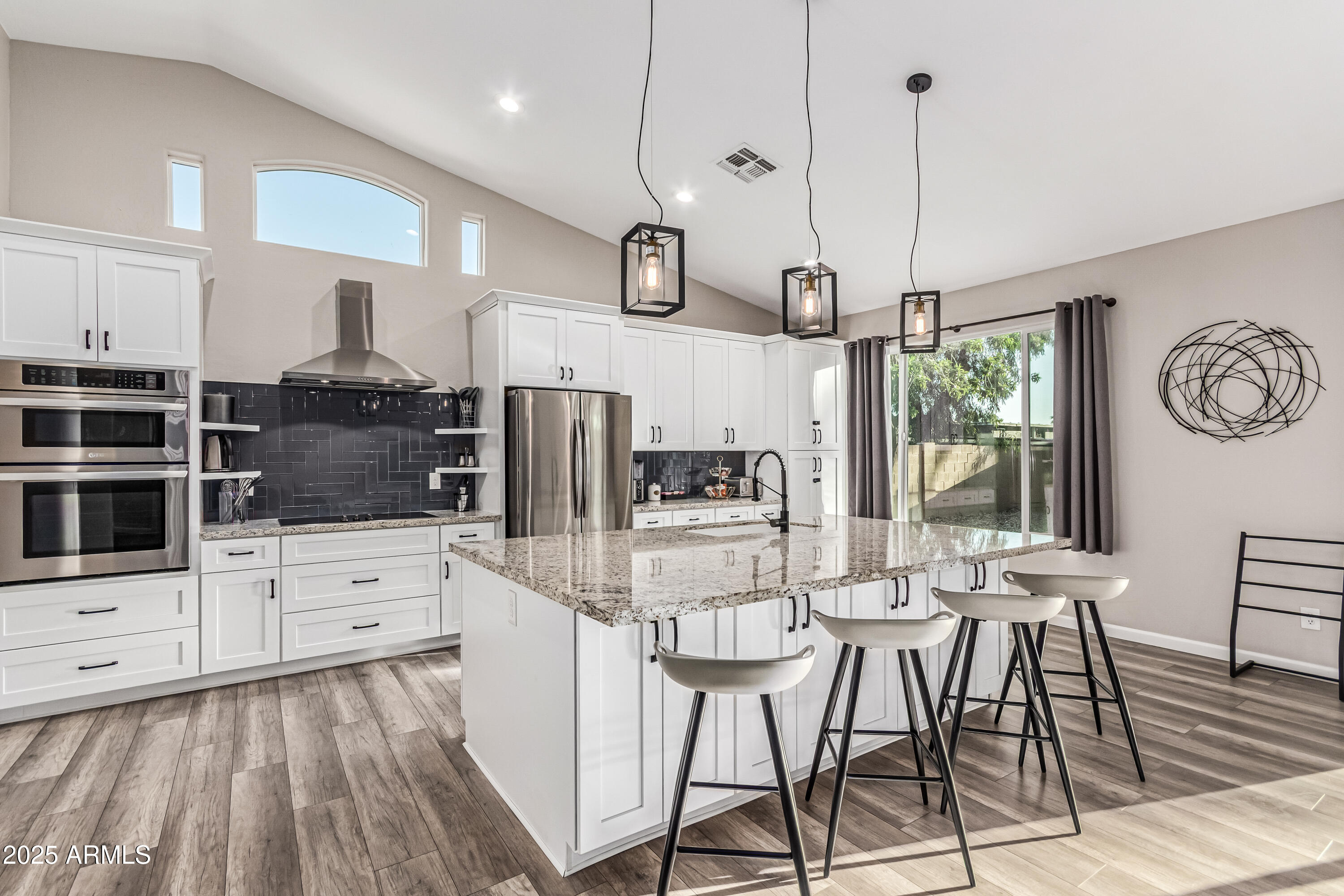 3438 North 30th Street Phoenix, AZ 85016 - Photo 5 of 26 a kitchen with stainless steel appliances kitchen island granite countertop a stove a refrigerator and white cabinets with wooden floors