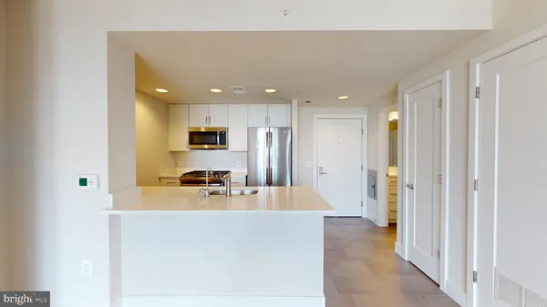 a view of a kitchen with a refrigerator and a sink