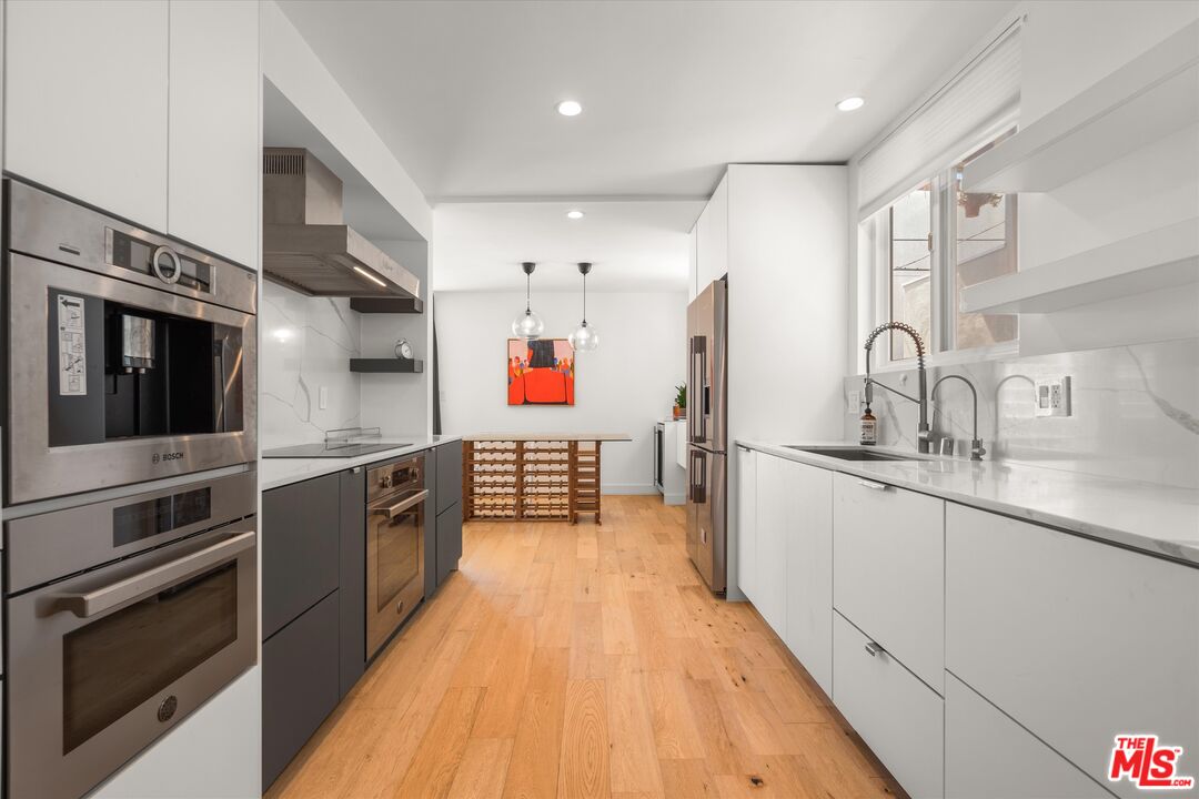 854 18th Street, Unit 6 Santa Monica, CA 90403 - Photo 7 of 22 a kitchen with stainless steel appliances granite countertop a sink and stove top oven