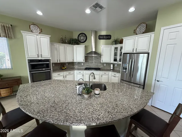 a kitchen with stainless steel appliances granite countertop a sink refrigerator and microwave