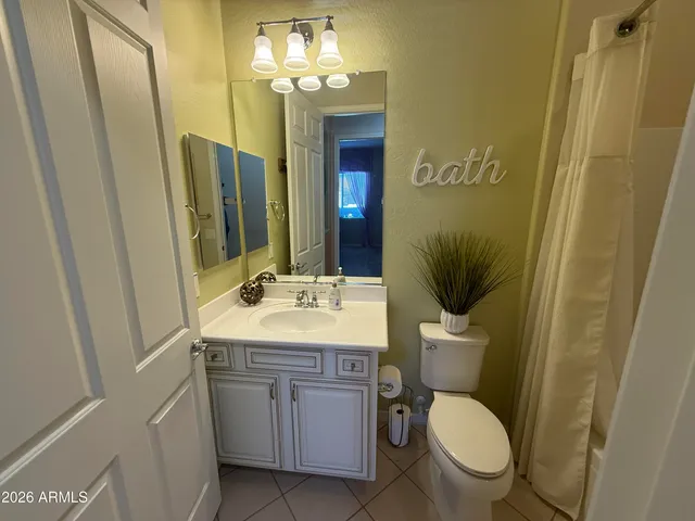 a bathroom with a granite countertop sink toilet and mirror