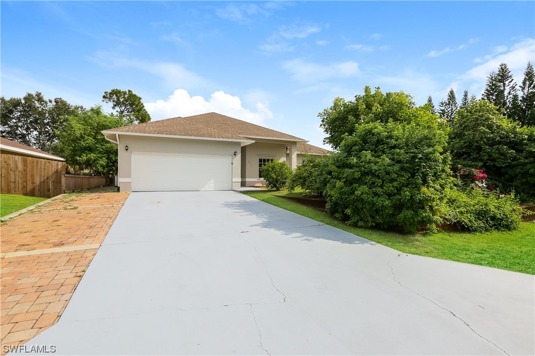 8373 Butternut Road Fort Myers, FL 33967 - Photo 1 of 13 a front view of a house with a yard and trees