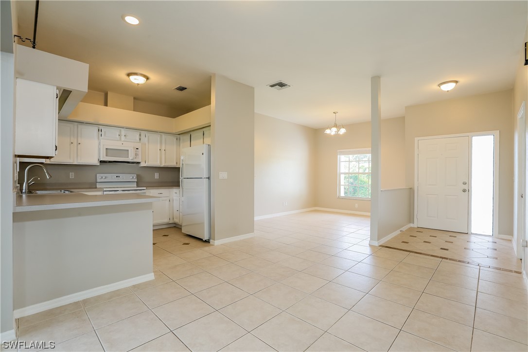8373 Butternut Road Fort Myers, FL 33967 - Photo 3 of 13 a kitchen with a refrigerator a sink and a stove top oven