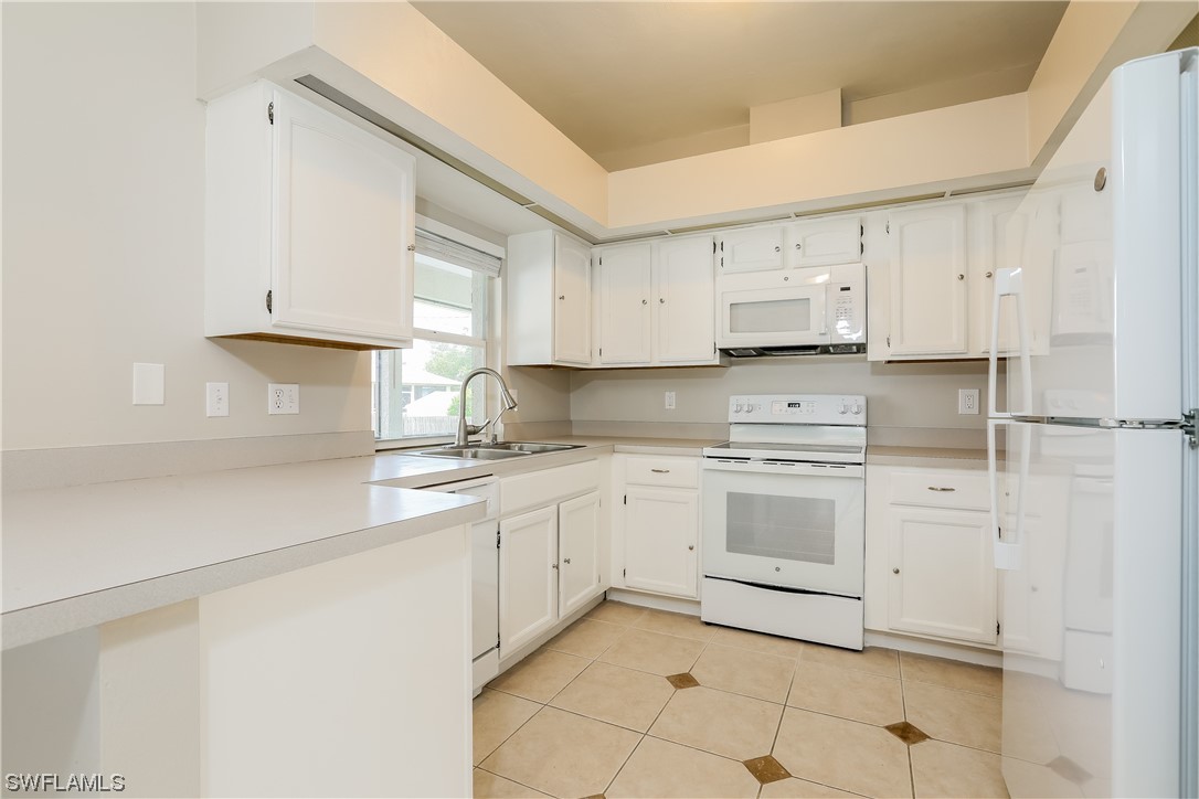 8373 Butternut Road Fort Myers, FL 33967 - Photo 4 of 13 a kitchen with cabinets appliances a sink and a counter top