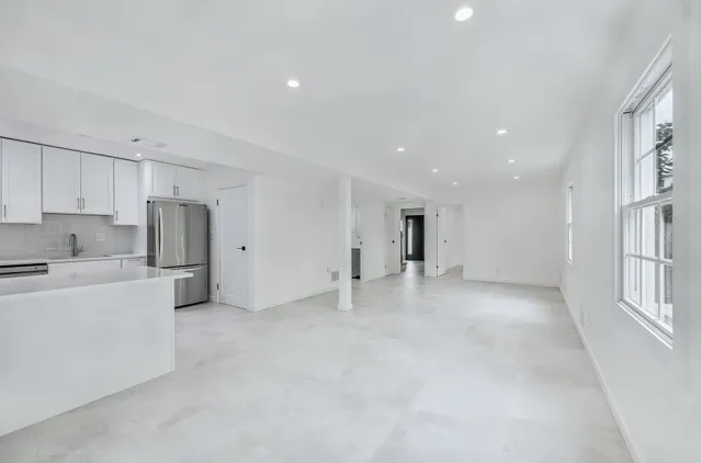 a view of a kitchen with a sink stove and cabinets