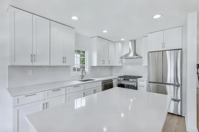 a kitchen with white cabinets and stainless steel appliances