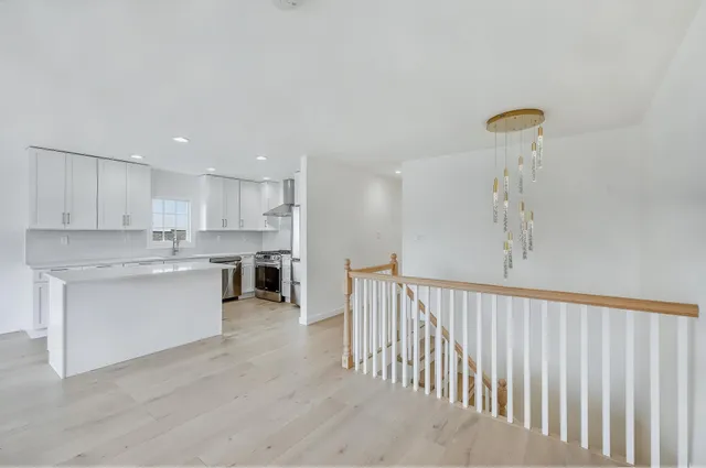 a kitchen with a white wooden cabinets and wooden floor