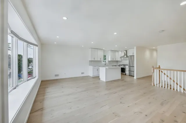 a view of a kitchen with kitchen island and stainless steel appliances