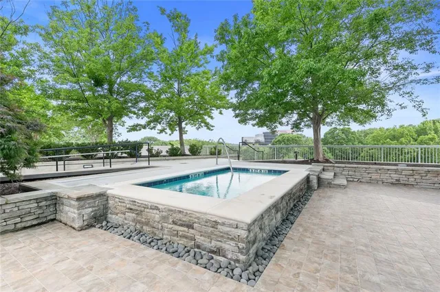 a view of a patio with a table and chairs under an umbrella with a small yard