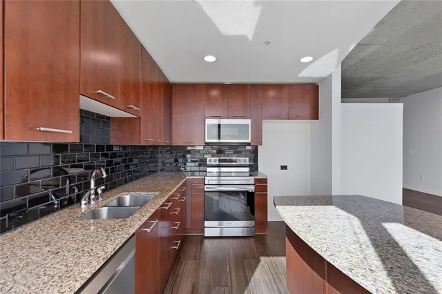a kitchen with stainless steel appliances granite countertop a sink stove and refrigerator