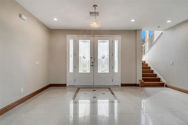 a view of a room with wooden floor chandelier and windows