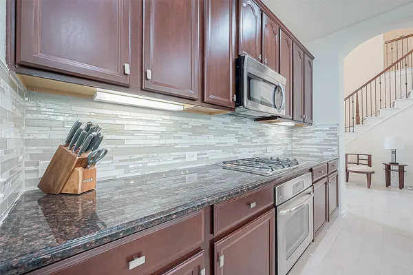 a kitchen with a sink a counter space appliances and cabinets