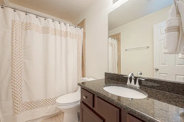 a front view of a house with a garden and trees