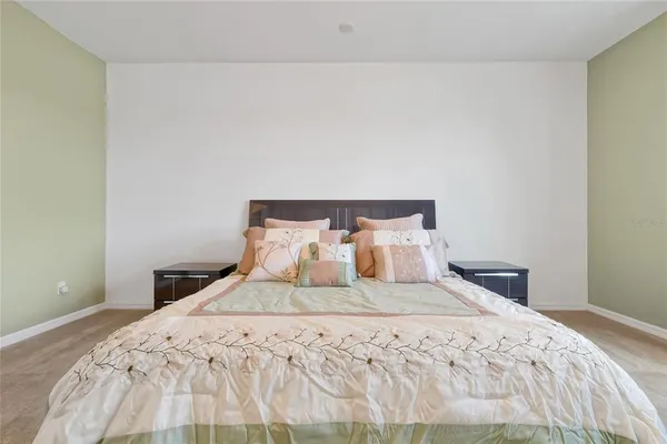 a spacious bedroom with a bed and a chandelier