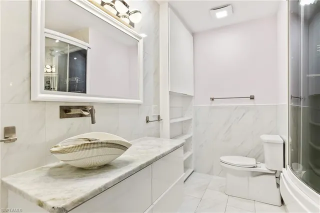 a bathroom with a granite countertop sink a toilet and a mirror