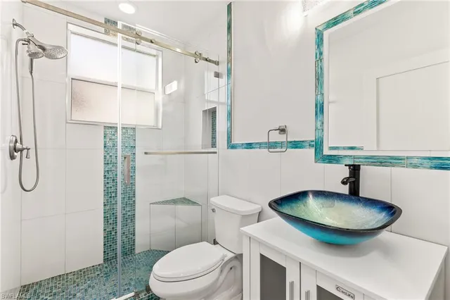 a bathroom with a sink toilet a mirror and shower