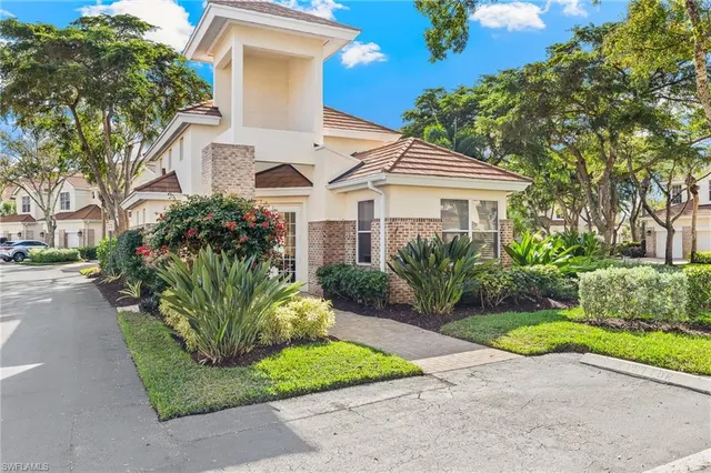 a front view of a house with a garden and plants