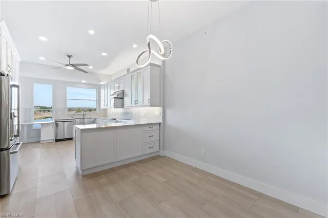 a view of a kitchen with a sink and dishwasher a refrigerator with wooden floor