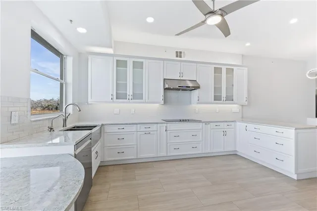 a spacious bathroom with double vanity sink a two mirror a window and a bathtub