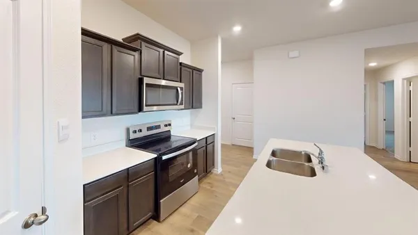 a kitchen with granite countertop cabinets stainless steel appliances and wooden floor