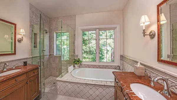 a bathroom with a granite countertop tub sink and mirror