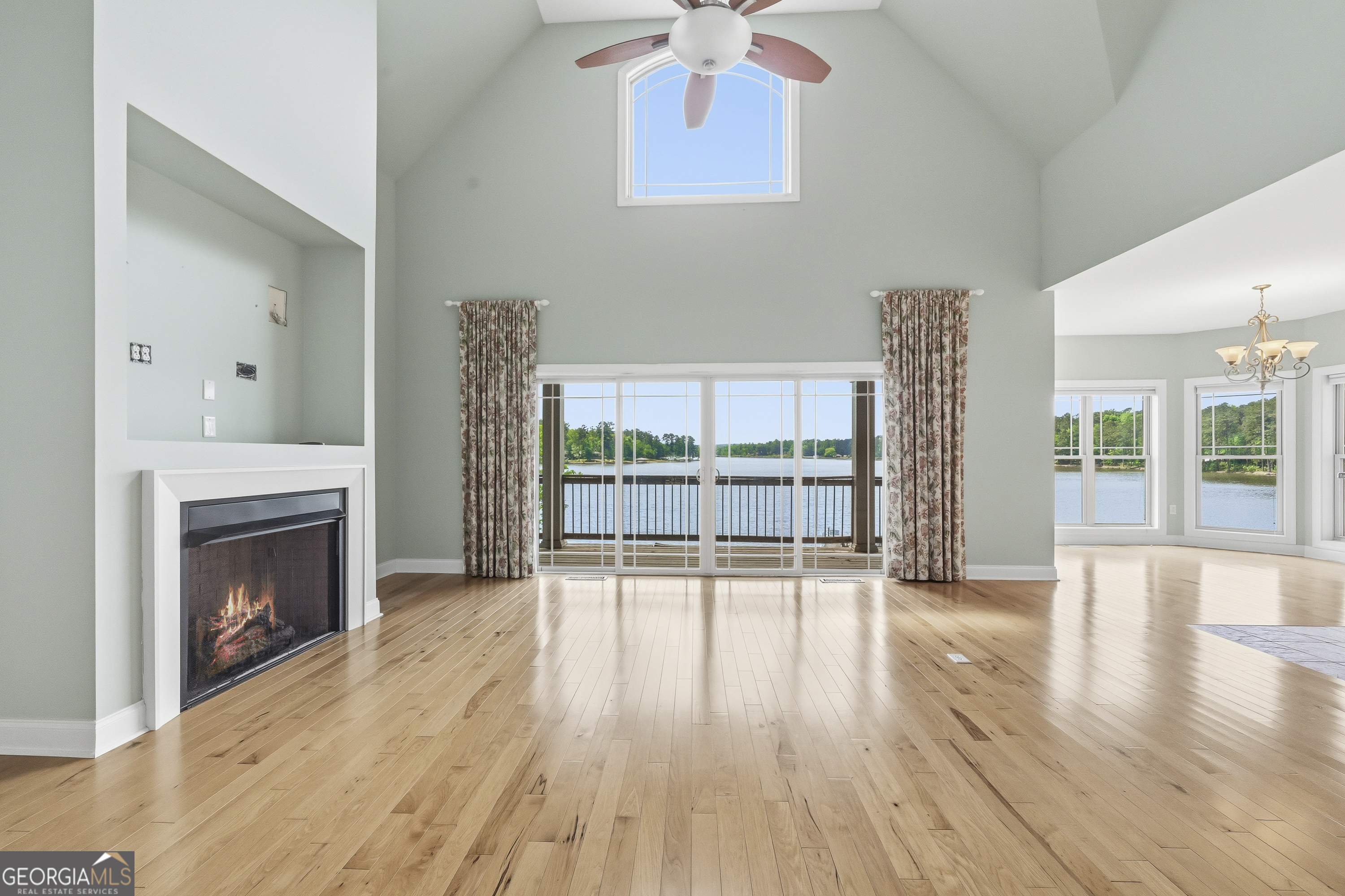 1038 Dennis Station Road Southwest Eatonton, GA 31024 - Photo 19 of 72 a view of an empty room with wooden floor and a fireplace