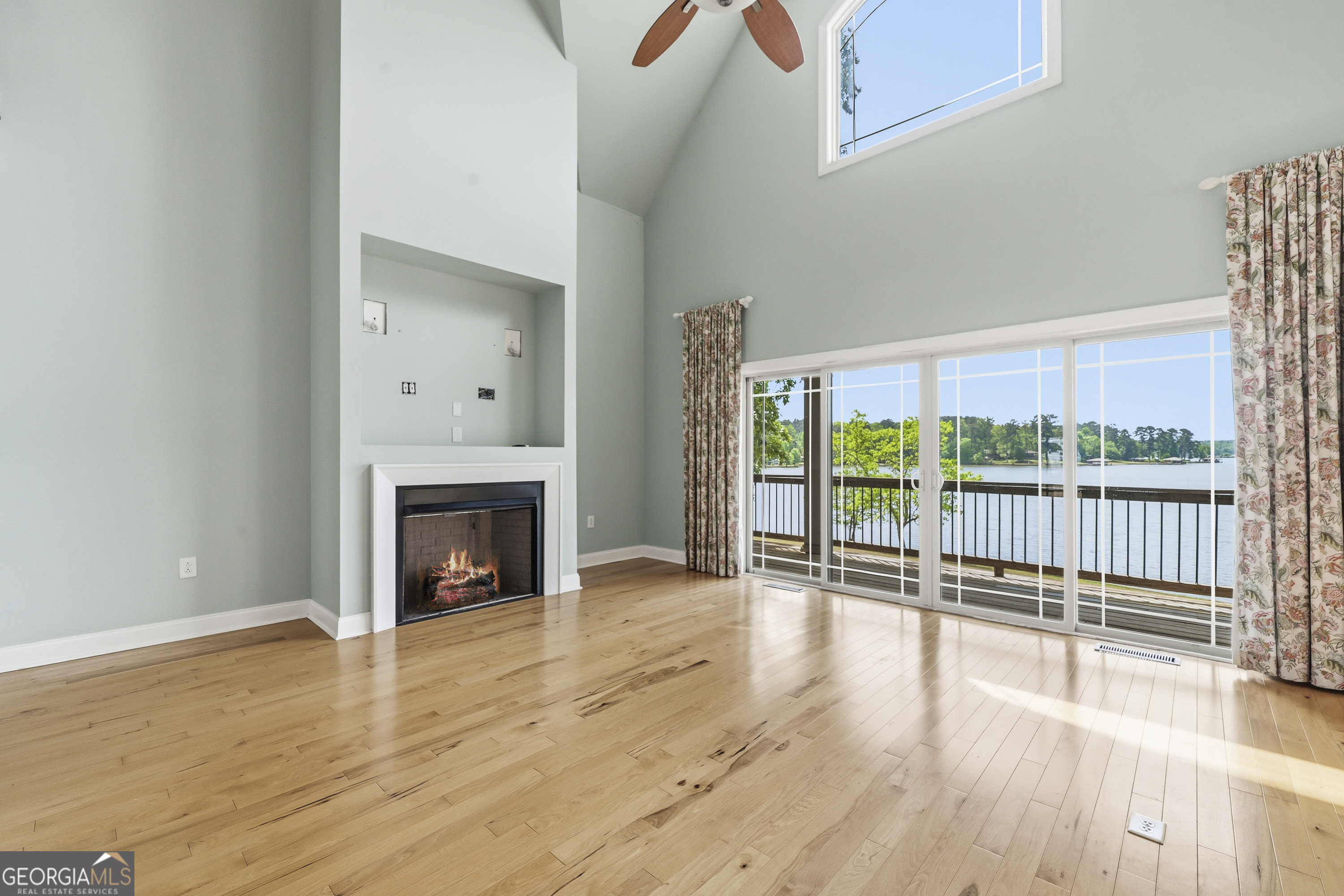 1038 Dennis Station Road Southwest Eatonton, GA 31024 - Photo 20 of 72 a view of a livingroom with wooden floor a fireplace and window